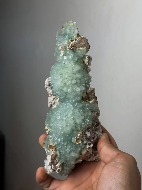 Sculptural green crystal formation with a natural matrix